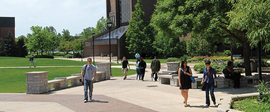 Students walking around campus on a sunny day.