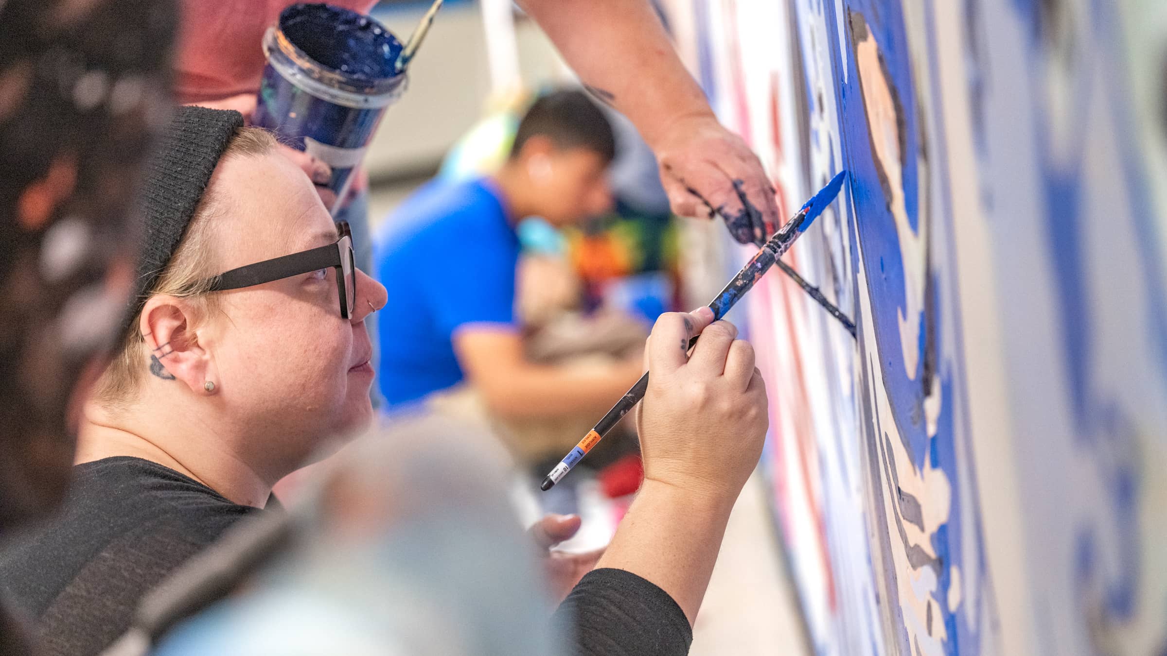 A group of BA in Art students paint a mural at Northeastern Illinois University