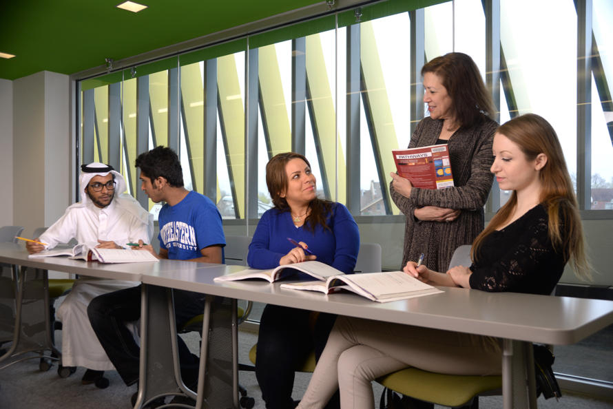 an instructors talking to four international students