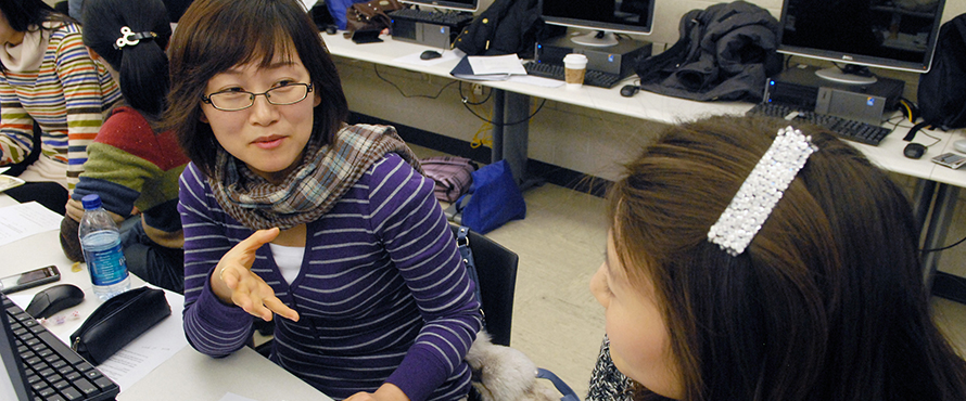 Two women having a discussion in class.