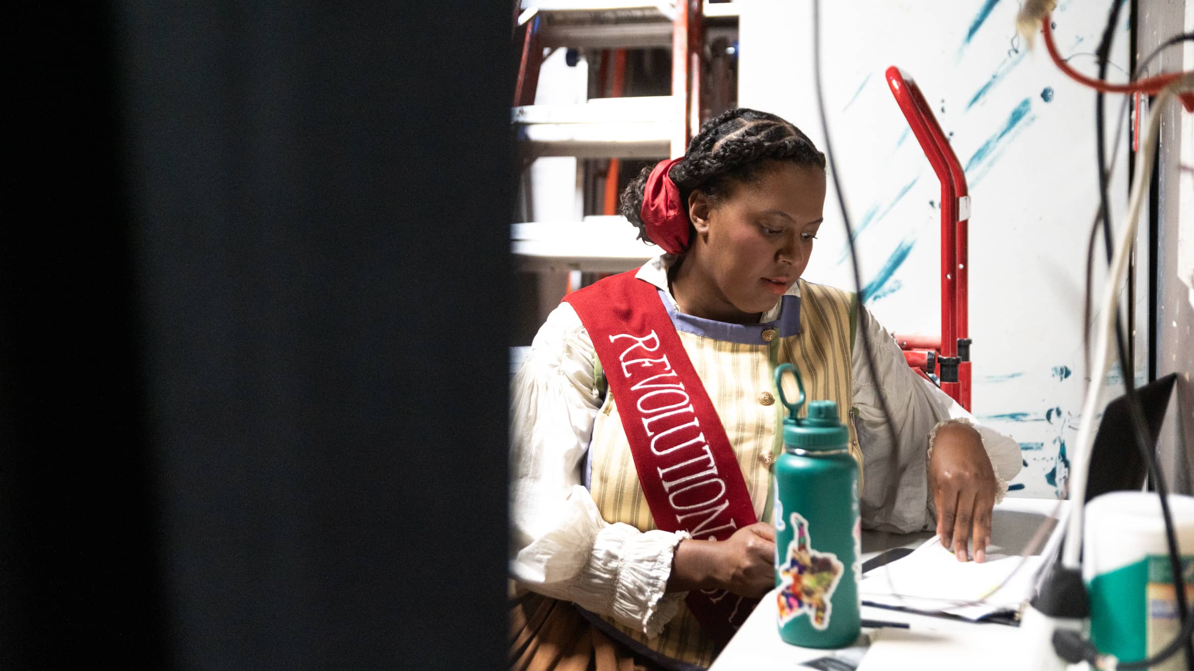 A female student in costume behind the scenes