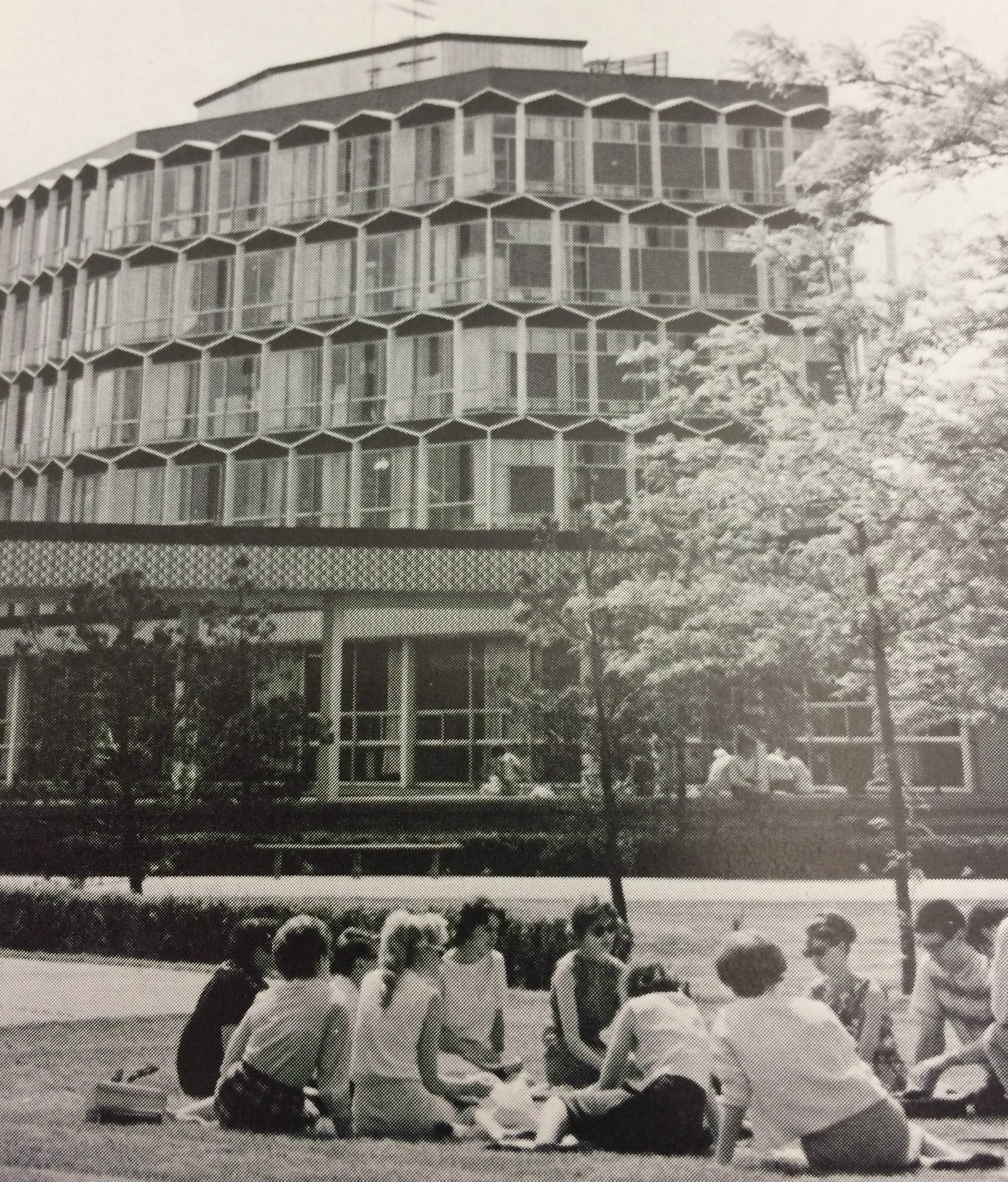 Members of the Class of 1967 sit in a circle on the lawn outside of the Sachs Building
