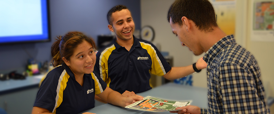 Student workers at Information Center assisting student.