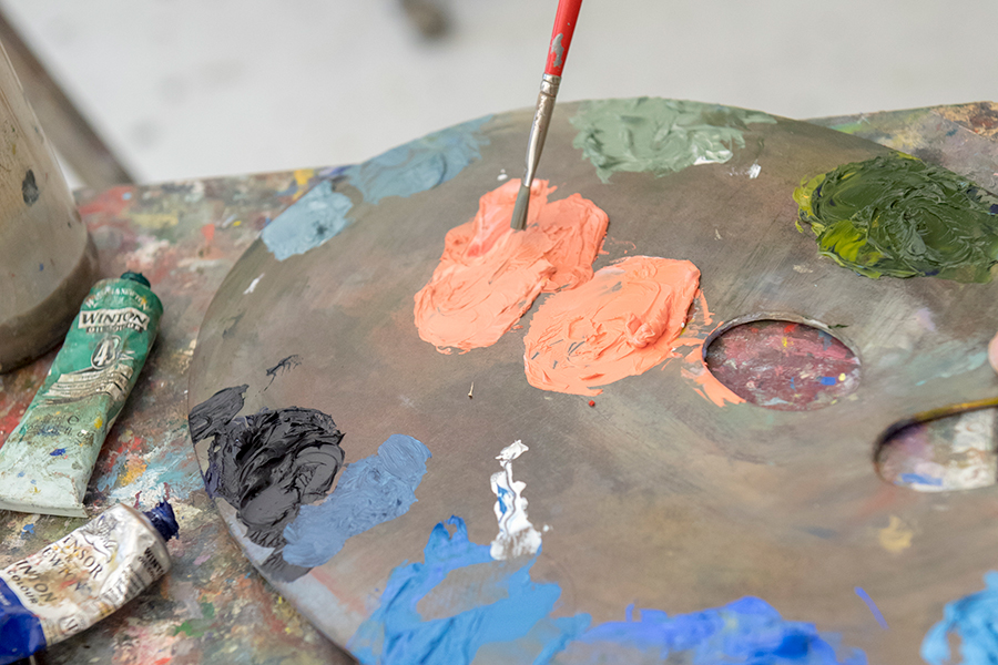 Paint brush being dipped in paint.