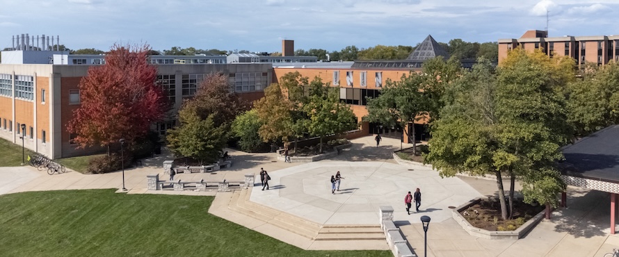 An aerial photo of Northeastern Illinois University's Main Campus on a sunny day. People are walking on the University Commons. The Student Union and Salme Harju Steinberg Fine Arts Center are also visible. 