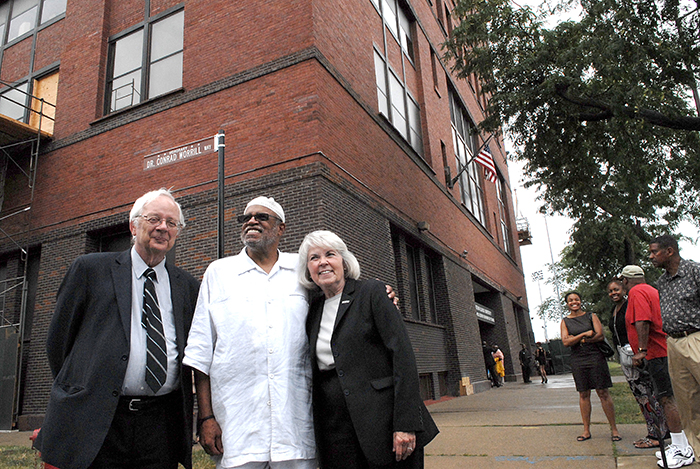 Conrad Worrill (center) poses in front of the honorary street sign near the Carruthers Center for Inner City Studies with President Sharon Hahs and her husband, Billy Hahs, on Aug. 22, 2013.