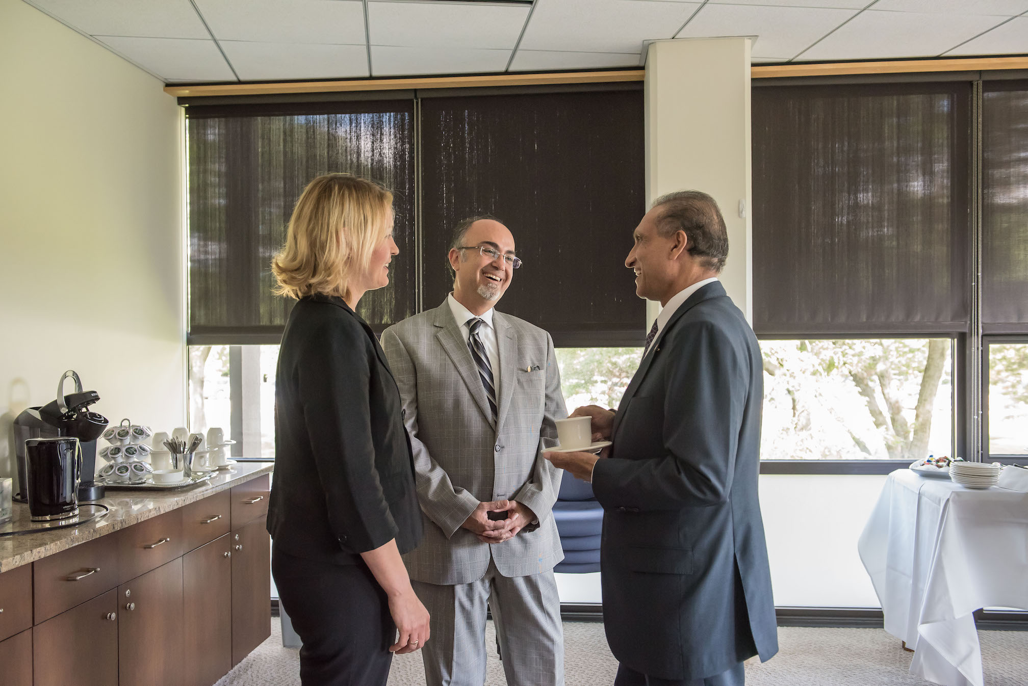 His Excellency Chaudhry, Vice President Liesl Downey and Dr. Farzaneh at the NEIU president's conference room carry a conversation at a small reception.