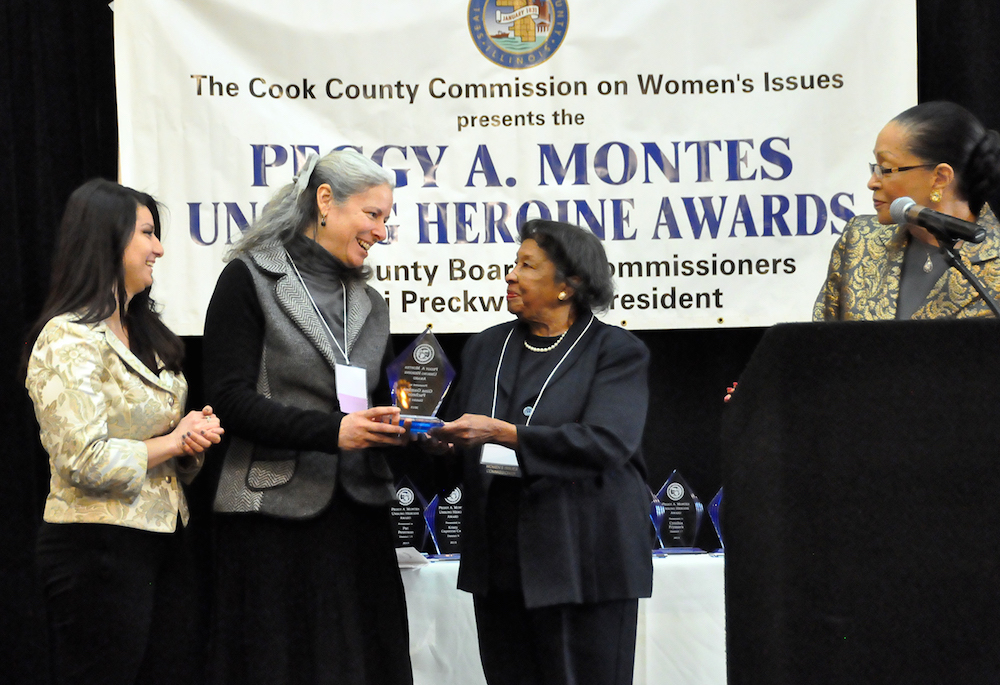 Gina Gamboa (second from left) received her award from Peggy A. Montes, chair of the Cook County Commission on Women’s Issues.