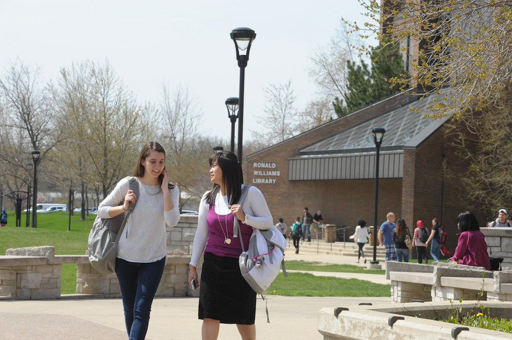 Two female students walking outdoors near the Ronald Williams Library