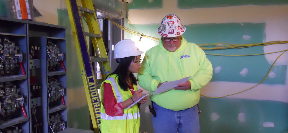Kevin Voda, right, general superintendent with Weis Builders, works with student Xiaoxuan Wu on the Nest construction site 