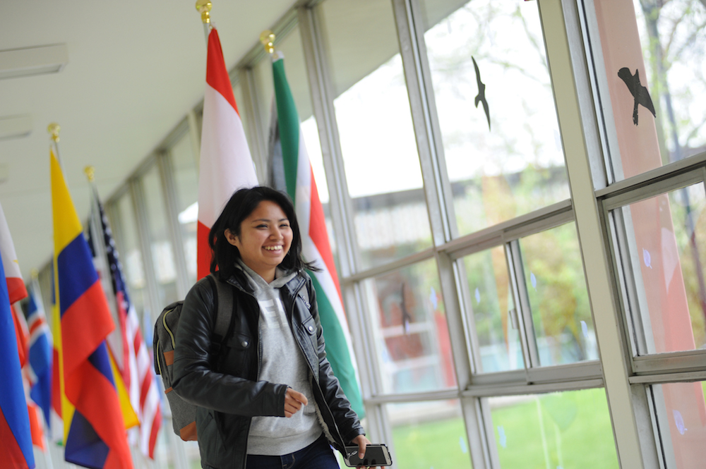 A student walks past flags of the world on the Main Campus.