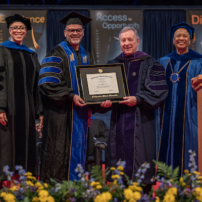 Provost, Board member, senator Durbin and University president wear regalia at commencement