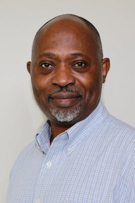 Photo of Professor Chielozona Eze in a light blue shirt against a gray background