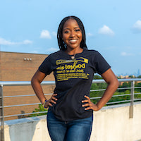 Photo of Destiny Davis in a black shirt with yellow text