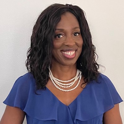 Photo of Dr. Ngozi Ezike smiling against an off white background in a blue top and pearl necklace.