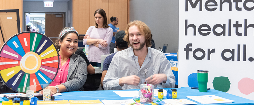 A photo of two community organization representatives tabling at the health fair