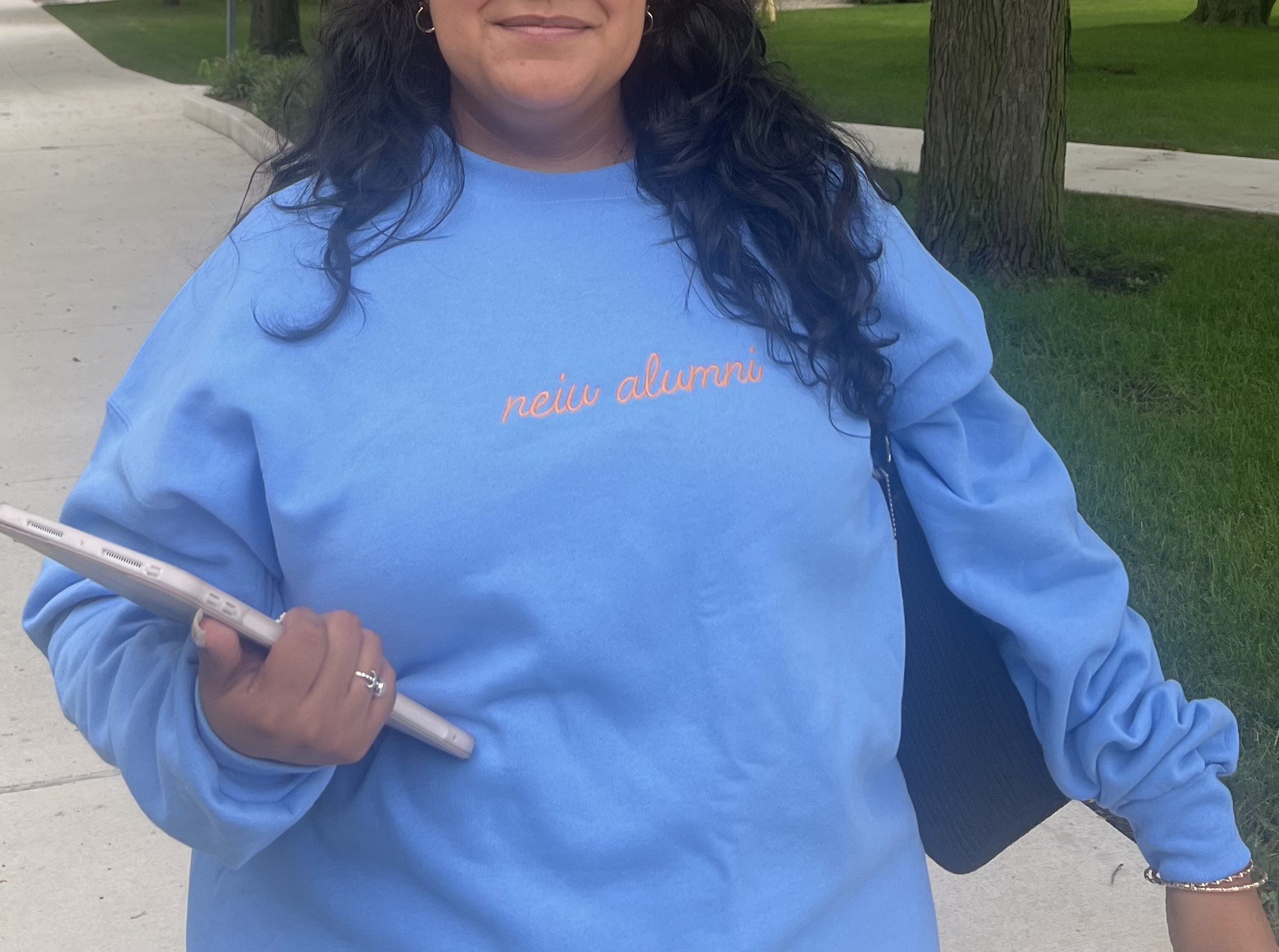 neiu alumni in cursive, golden writing on a blue crewneck