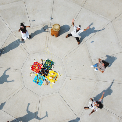 A circle of people engaged in dance as seen from directly overhead