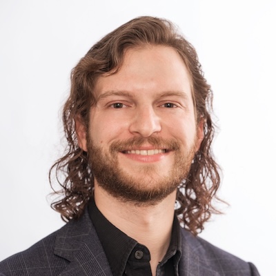 A headshot photo of Garo Agopian, Ph.D., smiling, wearing a dark suit against a white/gray background.