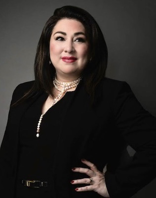 Photo of Olga Camargo wearing a black top against a gray background.