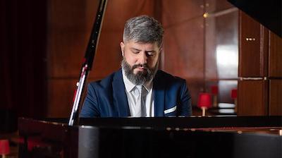 Pablo Estigarribia seated at a piano looking downward