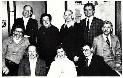 Photo of Northeastern Illinois University's Department of Speech and Performing Arts in 1982. Seated: Dr. James W. Barushok (chairperson), Richard Hesler, Marcella Velick (secretary), Dr. Bernard Brommell, Dr. David F. Unumb; Standing: Dr. Robert Walker, Gertrude Edelheit (administrative secretary), Durward Redd, Dr. David Jordan. 