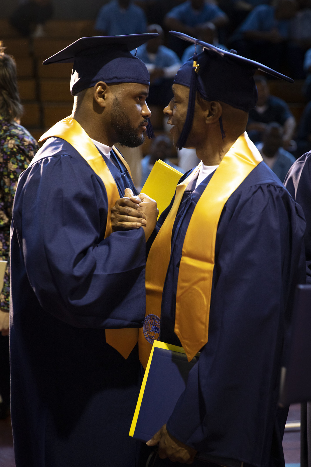 Two male graduates greet each other