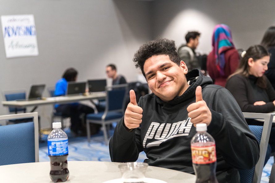 Student smiles and gives double thumbs up