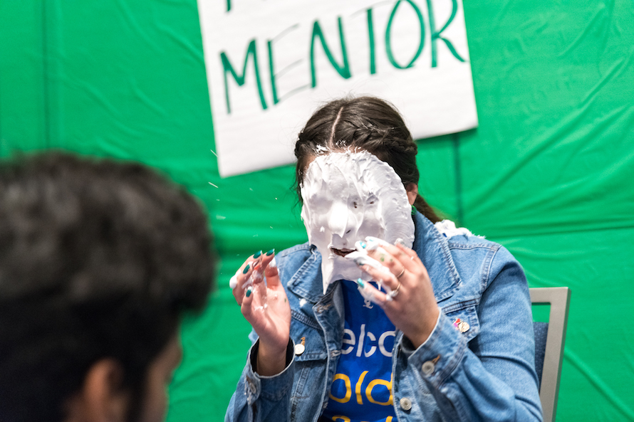 Shaving cream splashes off the face of an FYE Peer mentor as she is pied