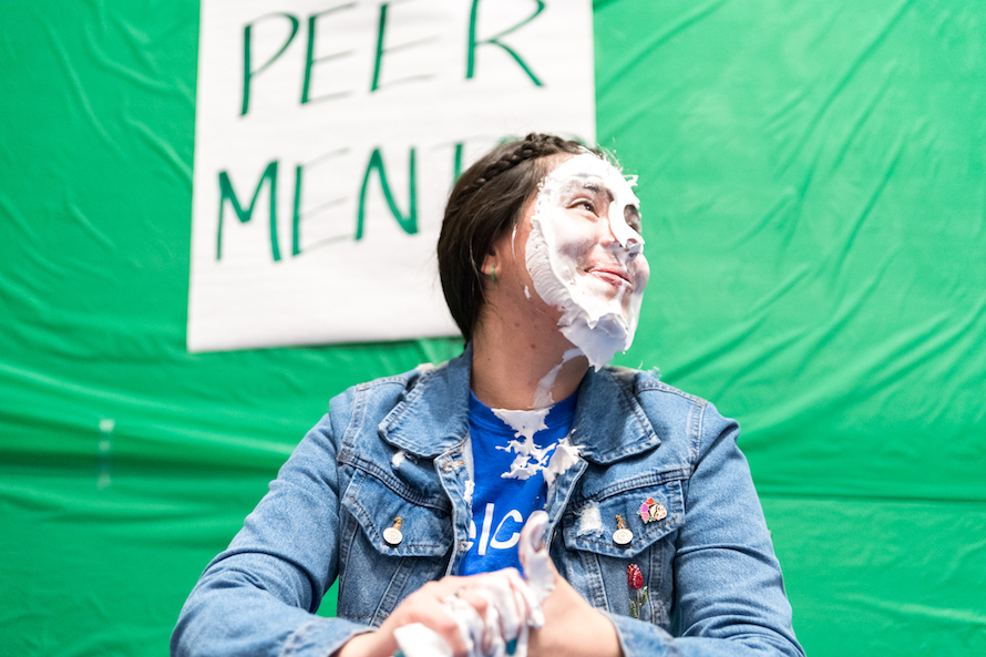 FYE Peer Mentor smiles with face covered in shaving cream after being pied.