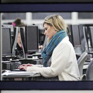 A photo of a person typing in a computer lab on Northeastern Illinois University's Main Campus. 