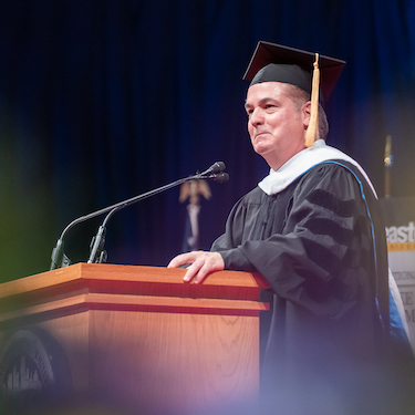 A photo of Juan Gabriel Moreno at the podium of Spring Commencement 2022.