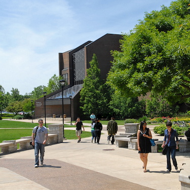 A photo of people walking around Northeastern's University Commons on a sunny day.