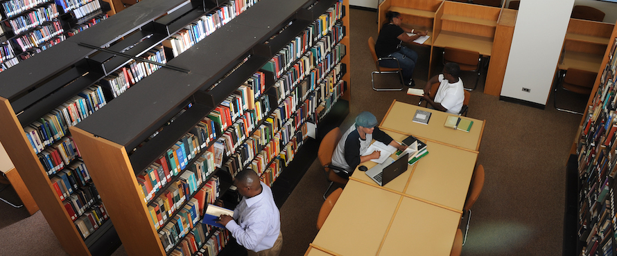 Students looking at books at the CCICS library