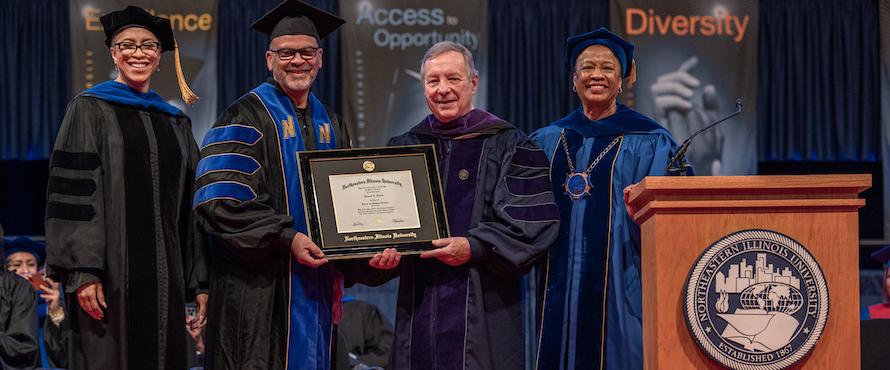 Photo of (left to right) Interim Provost Andrea Evans, NEIU Board of Trustees Officer Pro Tempore Marvin Garcia, U.S. Sen. Richard J. Durbin and NEIU President Gloria J. Gibson at the 2022 NEIU Commencement Ceremony wearing graduation gowns.