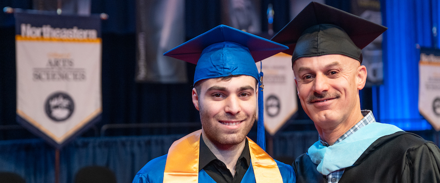 A photo of Johnny Shiba (left) and Dored Shiba (right) in their caps and gowns at Northeastern's December 2023 Commencement.