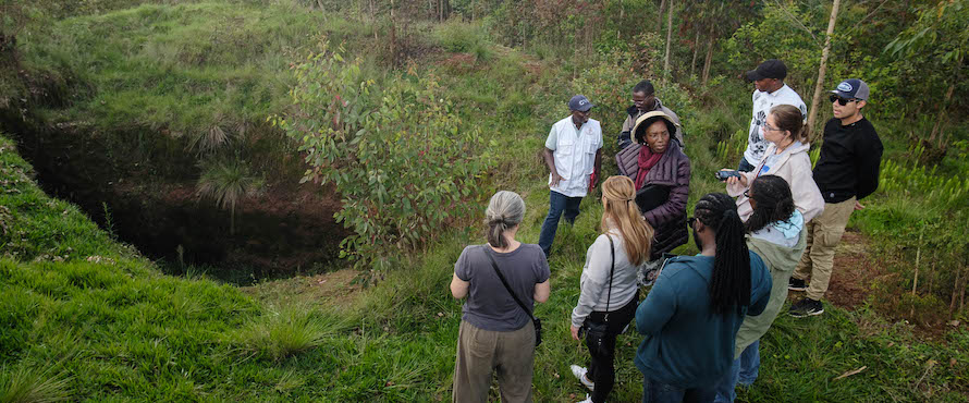 A photo of Jeanine Ntihirageza (group center) with Northeastern students, faculty and staff near a mass grave in Burundi during a study abroad trip in December 2023. Photo by Viktor Gerasimovski.