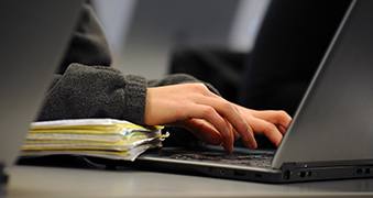 Student hands typing on a laptop