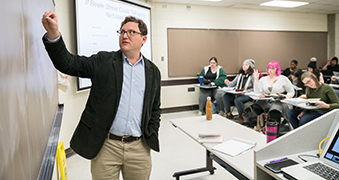 Professor lecturing in front of classroom.