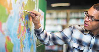 Northeastern student drawing on a map.