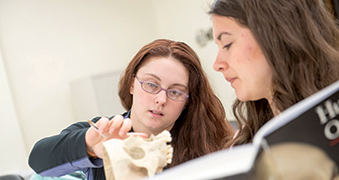 Two female students interacting in Anthropology class