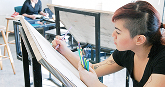 Female student drawing in art class