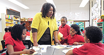 Female professor teaching young students.