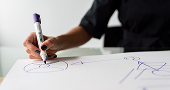 A student drawing on a whiteboard.