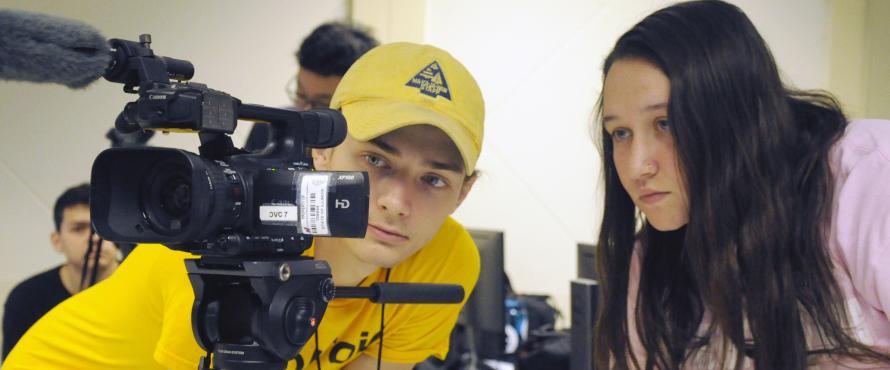 Students work on video in a classroom.