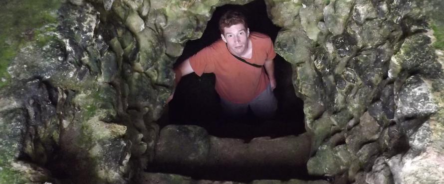 Student Eliot Monaco at the bottom of an ancient Maya tomb.