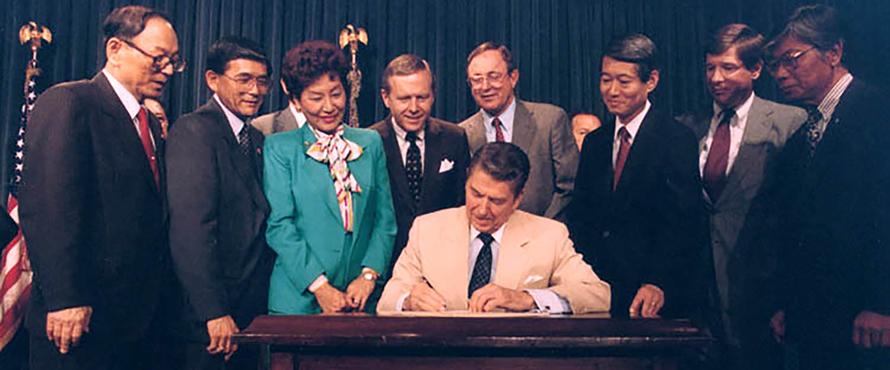 President Ronald Reagan signing Japanese reparations bill Aug. 10, 1988.