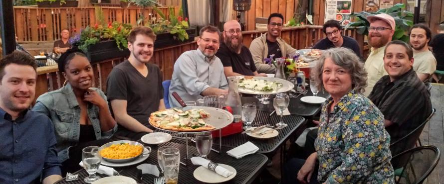 Philosophy graduates at a pizza party with faculty