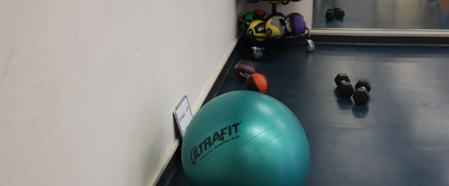 Green medicine ball on the floor of weight room.
