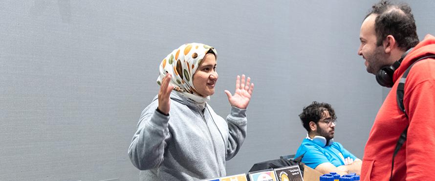 A photo of an NEIU department representative interacting with a student